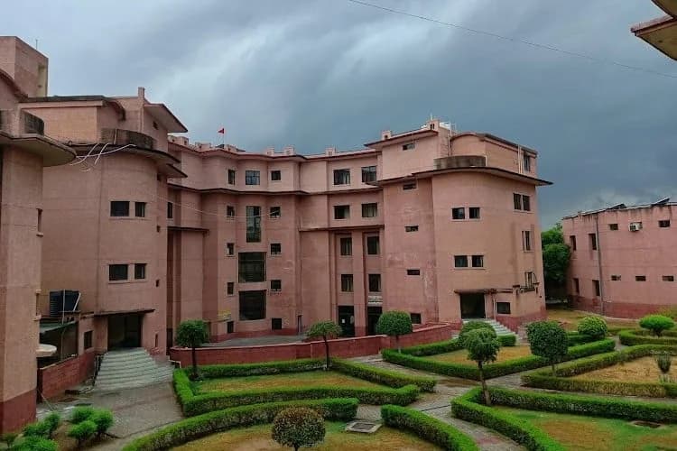 Jagannath University pink sandstone academic block with manicured gardens, Jaipur