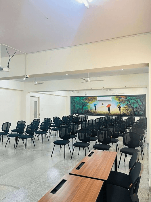 Seminar hall with rows of chairs and mural artwork at Rathinam School of Business, Bangalore